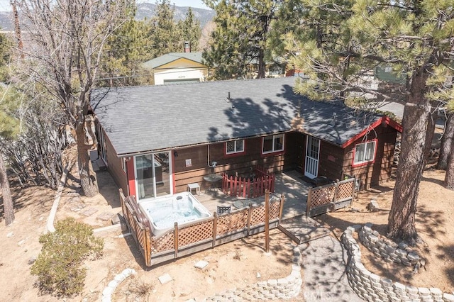 back of property with a patio area, a mountain view, and roof with shingles
