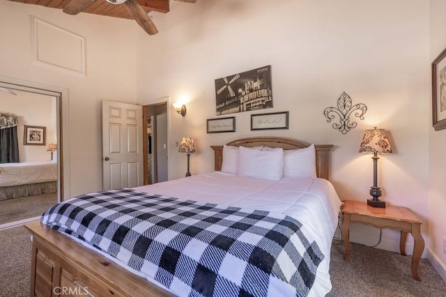 carpeted bedroom with baseboards and beam ceiling