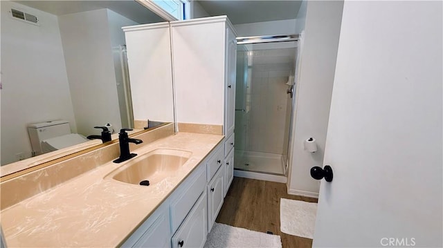 5201 Del Serra Cir, La Palma, CA 90623 - bathroom featuring wood finished floors, vanity, a stall shower, and toilet