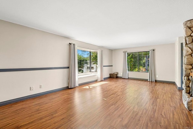 unfurnished living room with baseboards and wood finished floors
