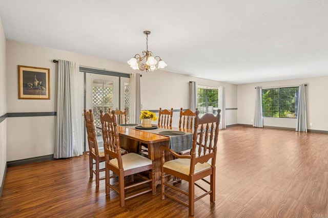 dining area with baseboards, a chandelier, and wood finished floors