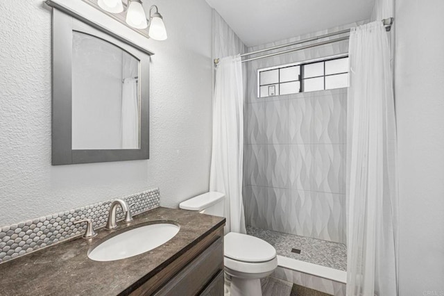bathroom with vanity, a textured wall, a stall shower, and toilet