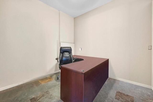 office space featuring baseboards and stone finish flooring