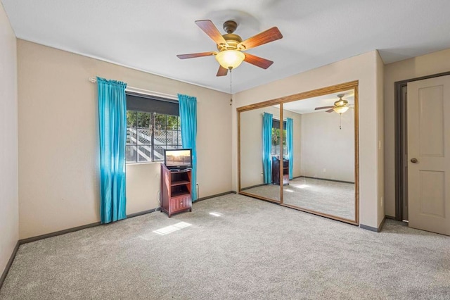 unfurnished bedroom with baseboards, ceiling fan, carpet, and a closet