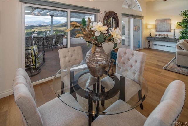 dining space with french doors, wood finished floors, and baseboards