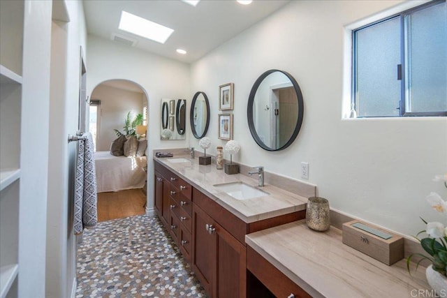 ensuite bathroom with double vanity, a sink, visible vents, and ensuite bath