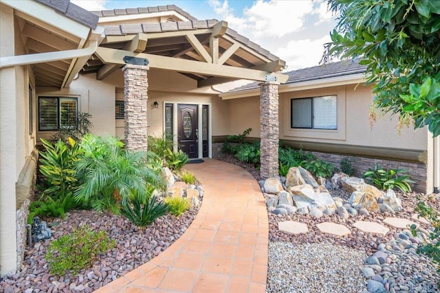 doorway to property featuring stucco siding and stone siding