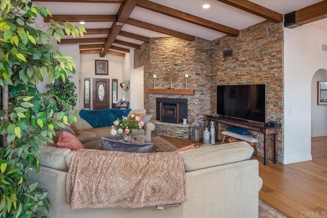 living room with baseboards, a stone fireplace, beam ceiling, recessed lighting, and wood finished floors