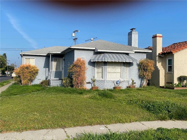 8802 S Wilton Pl, Los Angeles, CA 90047 - view of front of house with a front lawn, stucco siding, and a chimney