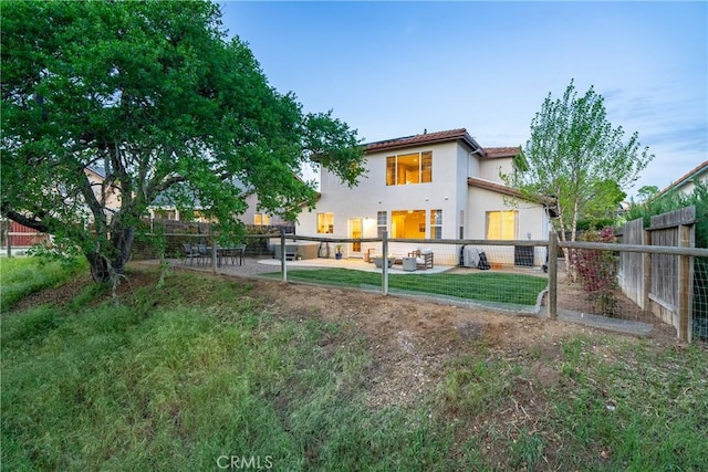 back of property with a fenced backyard and stucco siding