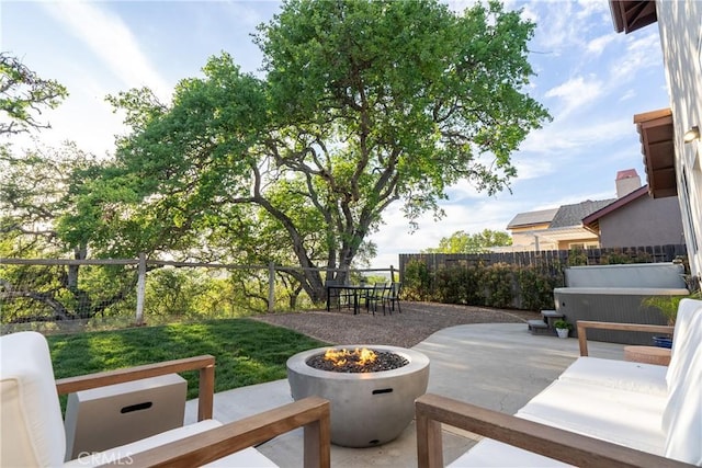 view of property's community featuring an outdoor living space with a fire pit, a patio area, and a fenced backyard