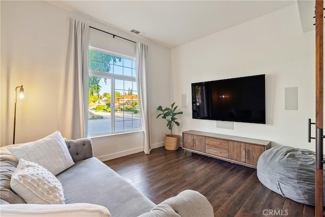 living room with visible vents, baseboards, and dark wood finished floors