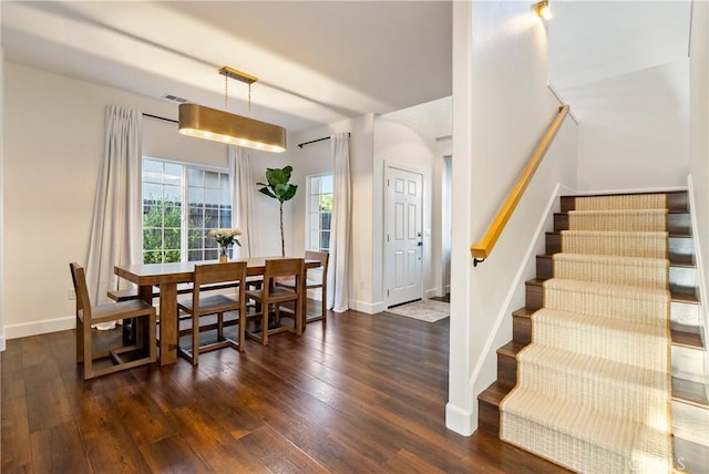 dining room with visible vents, dark wood finished floors, baseboards, and stairs