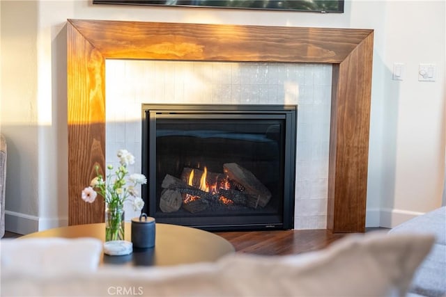 room details featuring baseboards and a tile fireplace