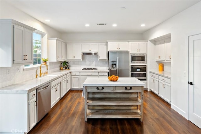 kitchen featuring tasteful backsplash, visible vents, a sink, light countertops, and appliances with stainless steel finishes