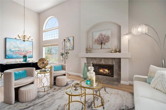 4930 Rockhampton Ct, Yorba Linda, CA 92887 - sitting room featuring wood finished floors, a towering ceiling, a fireplace, a chandelier, and baseboards