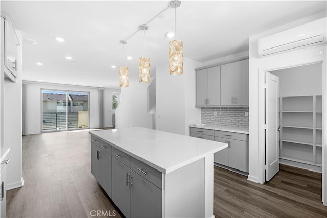 225 Scratch Rd, Covina, CA 91722 - kitchen featuring gray cabinetry, a wall mounted AC, dark wood-style floors, a kitchen island, and recessed lighting