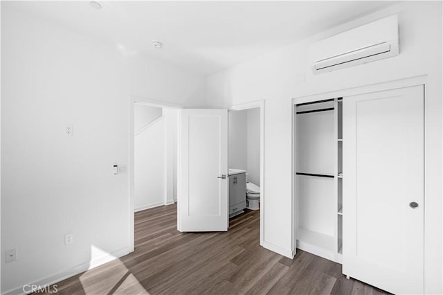 225 Scratch Rd, Covina, CA 91722 - unfurnished bedroom featuring a wall mounted AC, wood finished floors, and baseboards