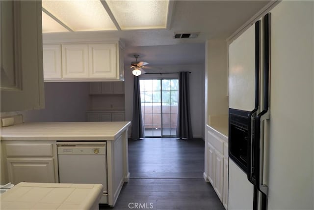 kitchen featuring white cabinets, white appliances, a ceiling fan, dark wood-type flooring, and visible vents