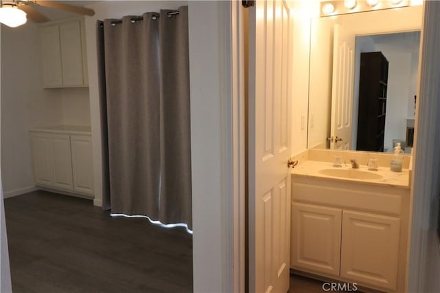 bathroom featuring ceiling fan, wood finished floors, and vanity