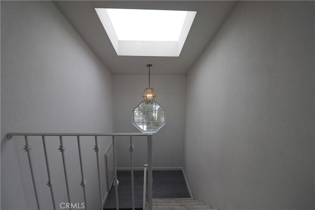staircase with a skylight and baseboards