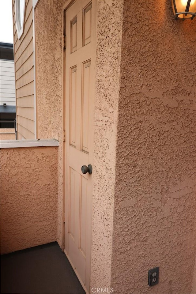 view of exterior entry featuring stucco siding
