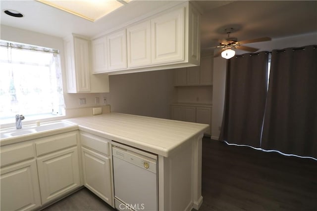 kitchen with a peninsula, ceiling fan, white cabinets, a sink, and dishwasher