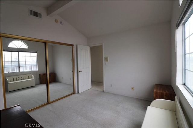 unfurnished room featuring vaulted ceiling with beams, light carpet, and visible vents