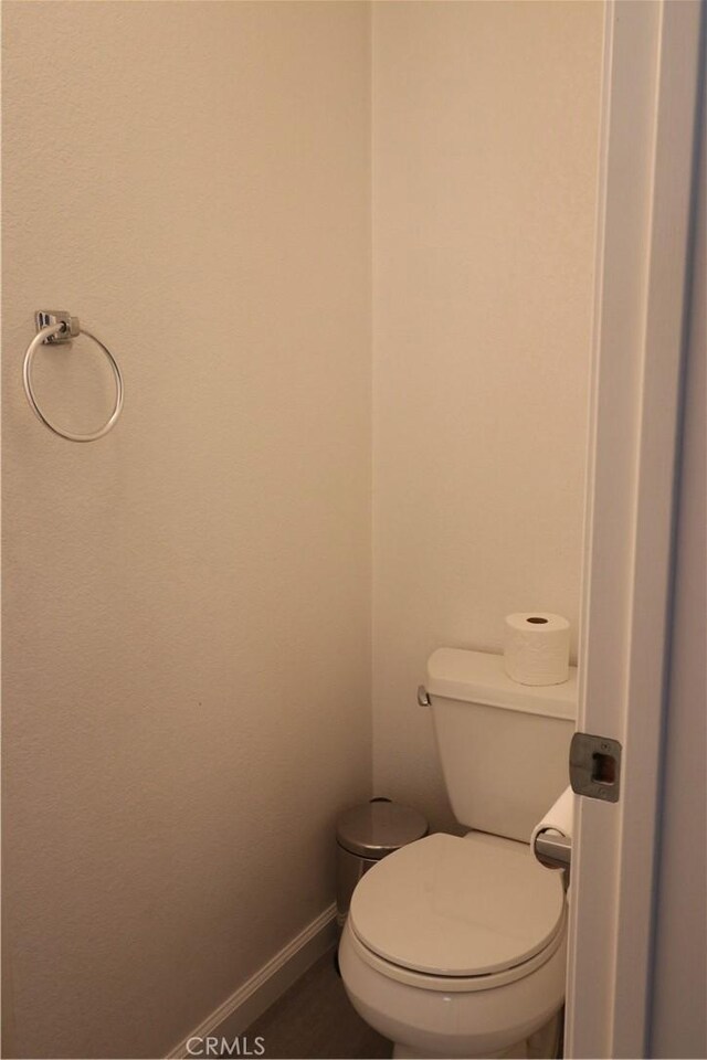 bathroom featuring baseboards and toilet