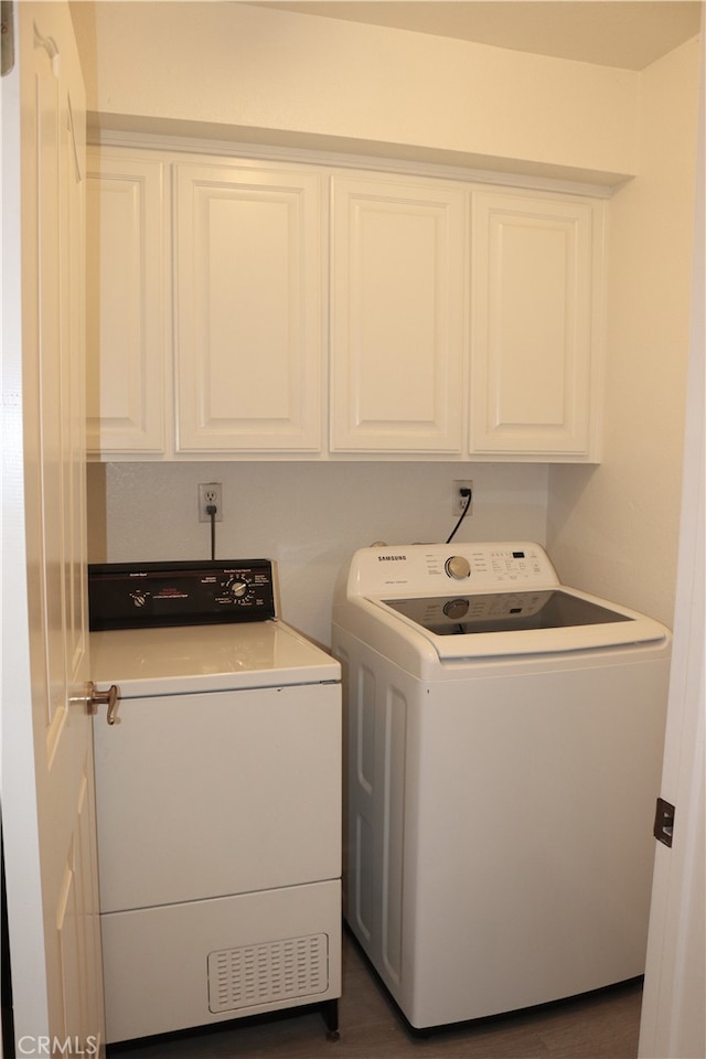 clothes washing area with cabinet space and washing machine and dryer