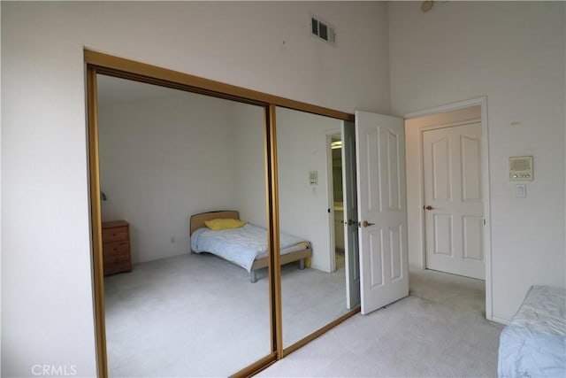 unfurnished bedroom with visible vents, light carpet, and a closet
