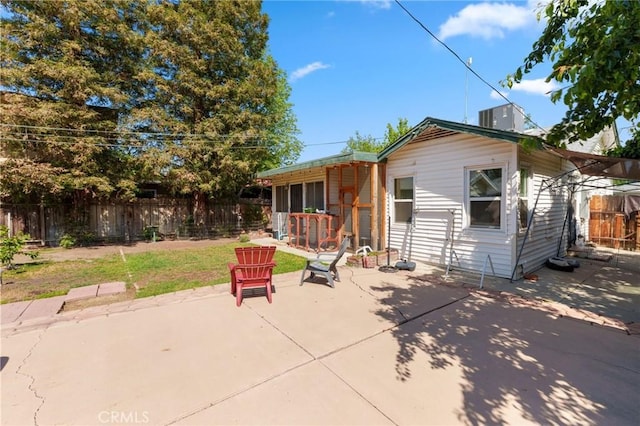 rear view of property with a patio, central AC, and fence