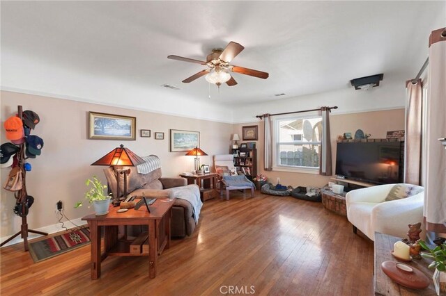 living room featuring ceiling fan, wood finished floors, and visible vents