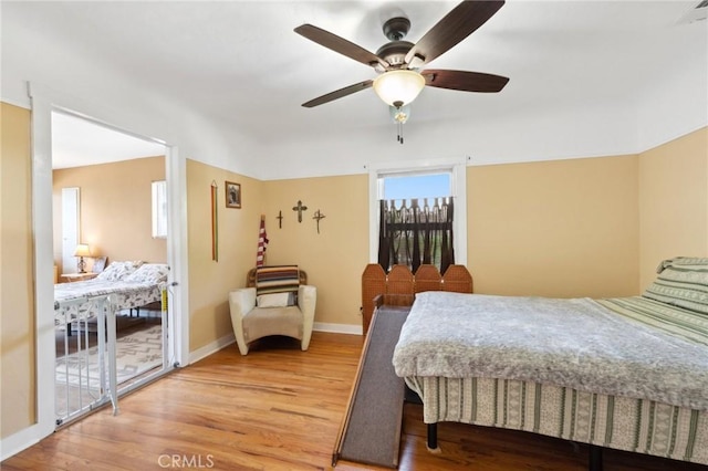 bedroom featuring light wood-style floors, baseboards, and ceiling fan