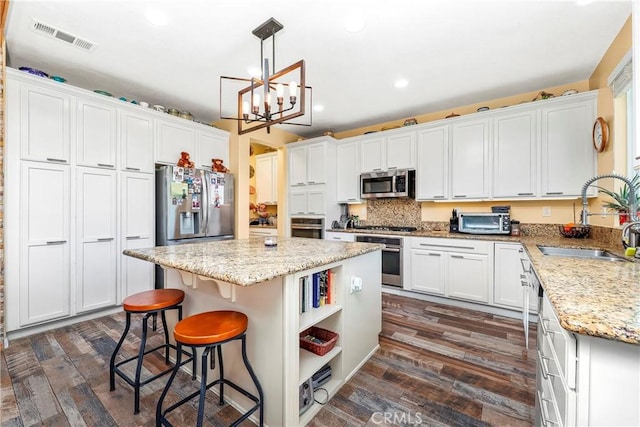 3565 Louer Dr, Lancaster, CA 93536 - kitchen with white cabinets, a sink, visible vents, stainless steel appliances, and a center island