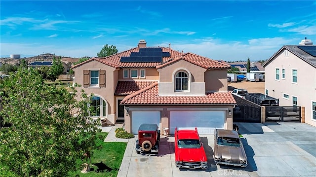 3565 Louer Dr, Lancaster, CA 93536 - mediterranean / spanish house with concrete driveway, a gate, a tiled roof, solar panels, and stucco siding