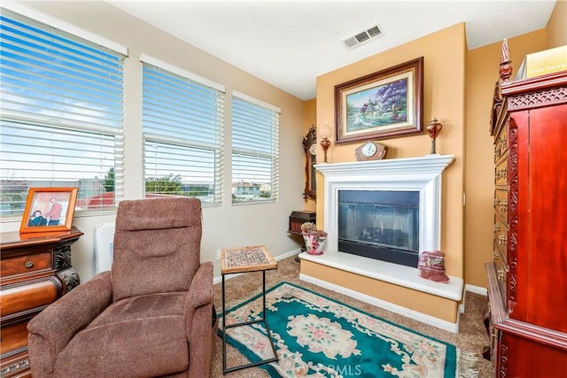 3565 Louer Dr, Lancaster, CA 93536 - sitting room featuring carpet flooring, visible vents, baseboards, and a glass covered fireplace