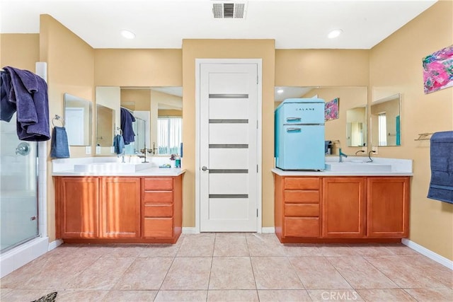 3565 Louer Dr, Lancaster, CA 93536 - bathroom featuring a shower stall, visible vents, baseboards, two vanities, and tile patterned floors