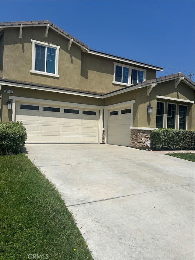 6974 Canterra Way, Fontana, CA 92336 - view of front facade featuring a garage, stucco siding, concrete driveway, and stone siding