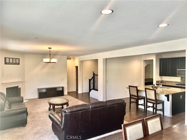 6974 Canterra Way, Fontana, CA 92336 - living room featuring a textured ceiling, recessed lighting, stairway, a fireplace, and a chandelier