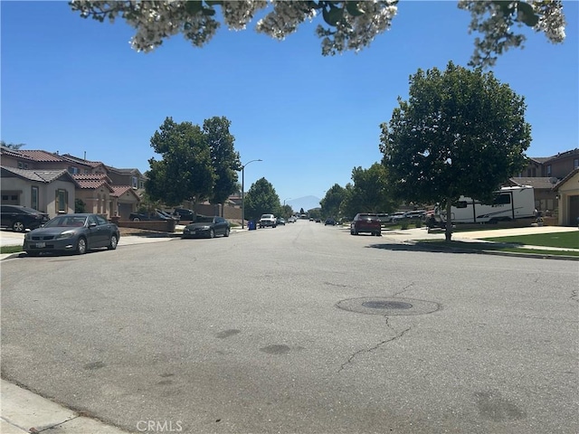 6974 Canterra Way, Fontana, CA 92336 - view of asphalt street featuring sidewalks, curbs, a residential view, and street lighting