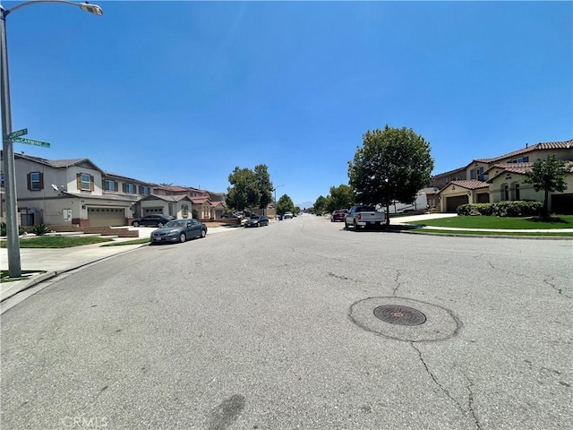 6974 Canterra Way, Fontana, CA 92336 - view of asphalt road featuring sidewalks, a residential view, and curbs