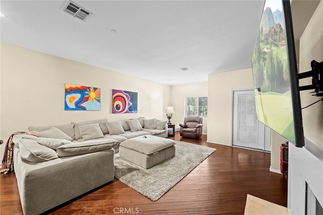 living room featuring baseboards, dark wood-style floors, and visible vents