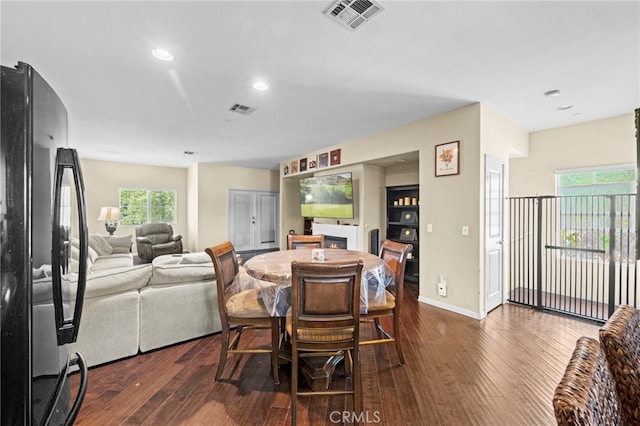 dining area with dark wood-style flooring, baseboards, visible vents, and recessed lighting