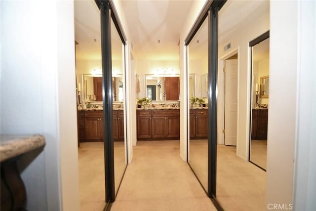 hallway featuring light carpet and visible vents