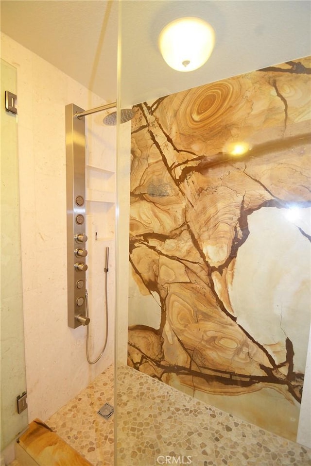 bathroom featuring a shower with door