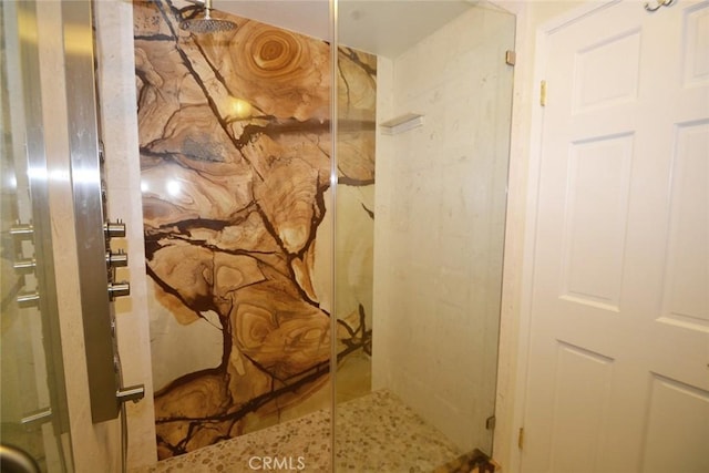 bathroom featuring a marble finish shower