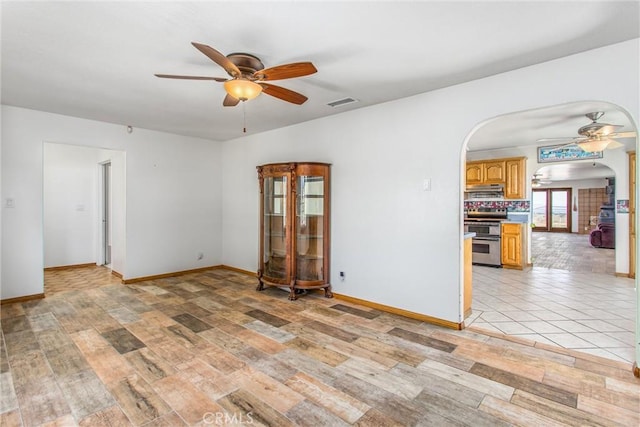 7045 Oak Hill Rd, Oak Hills, CA 92344 - empty room with arched walkways, visible vents, baseboards, and ceiling fan