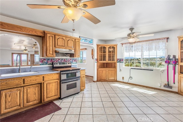 7045 Oak Hill Rd, Oak Hills, CA 92344 - kitchen with arched walkways, a sink, ceiling fan, under cabinet range hood, and double oven range