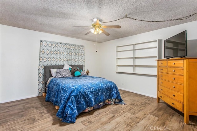 7045 Oak Hill Rd, Oak Hills, CA 92344 - bedroom featuring ceiling fan, a textured ceiling, baseboards, and wood finished floors